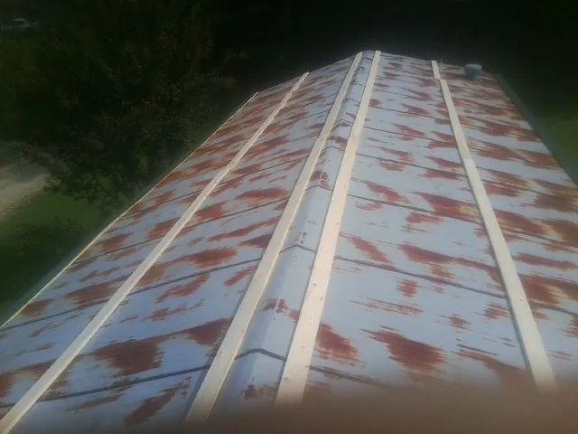 Rusted metal roof panels with new wood purlins before replacement — Storm Damage Roof Repair in Pedro Bay by Roofing Brothers